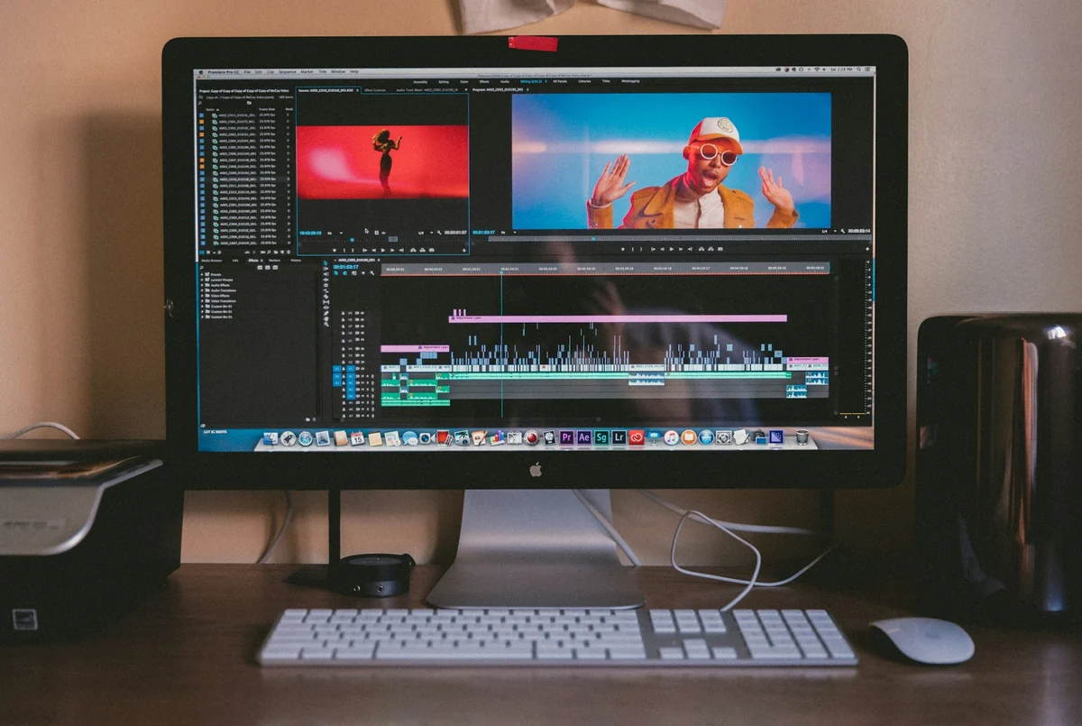 A computer screen running video editing software with two colorful preview windows and a timeline