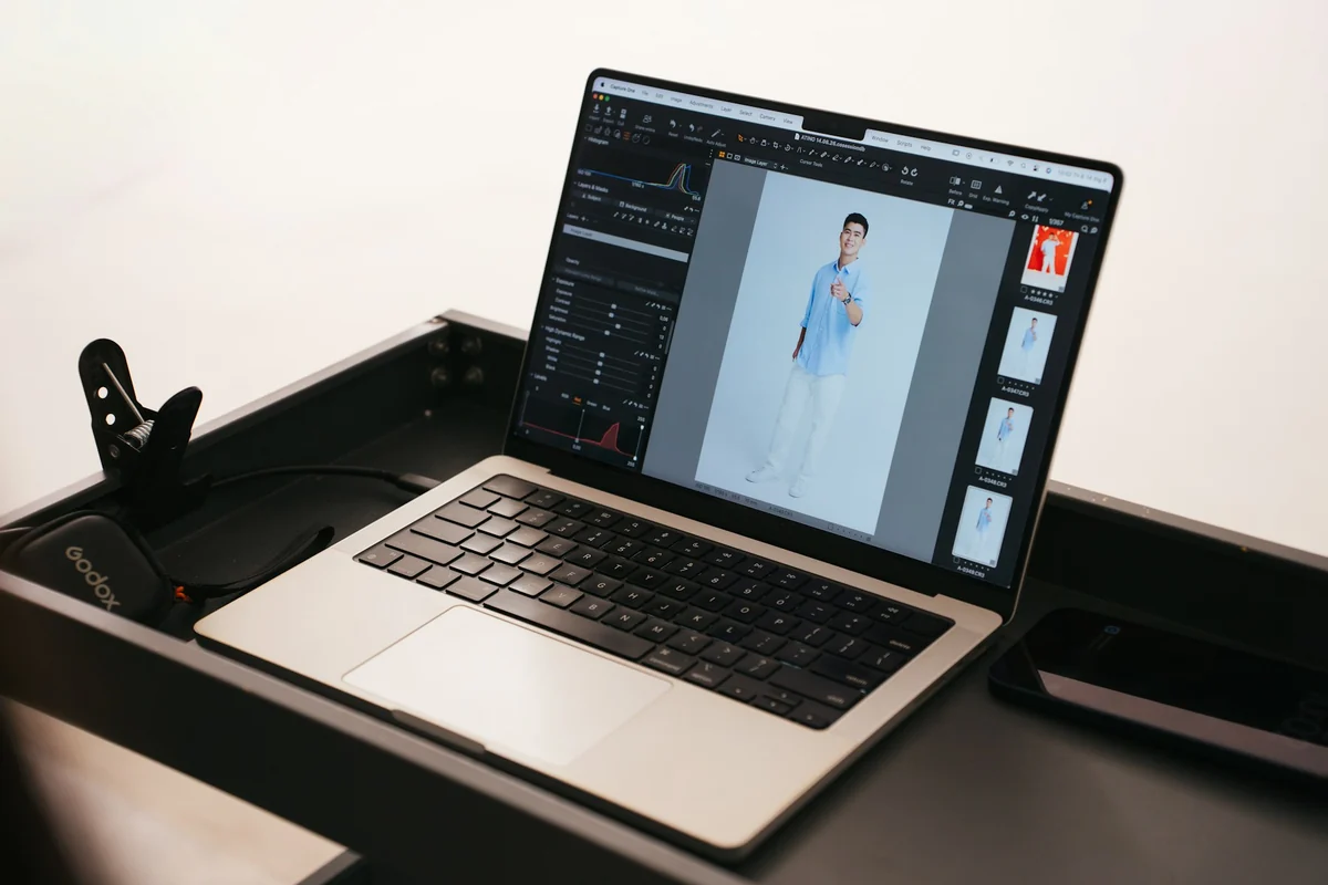 A laptop running photo editing software, showing a full-length photo of a person in a blue shirt