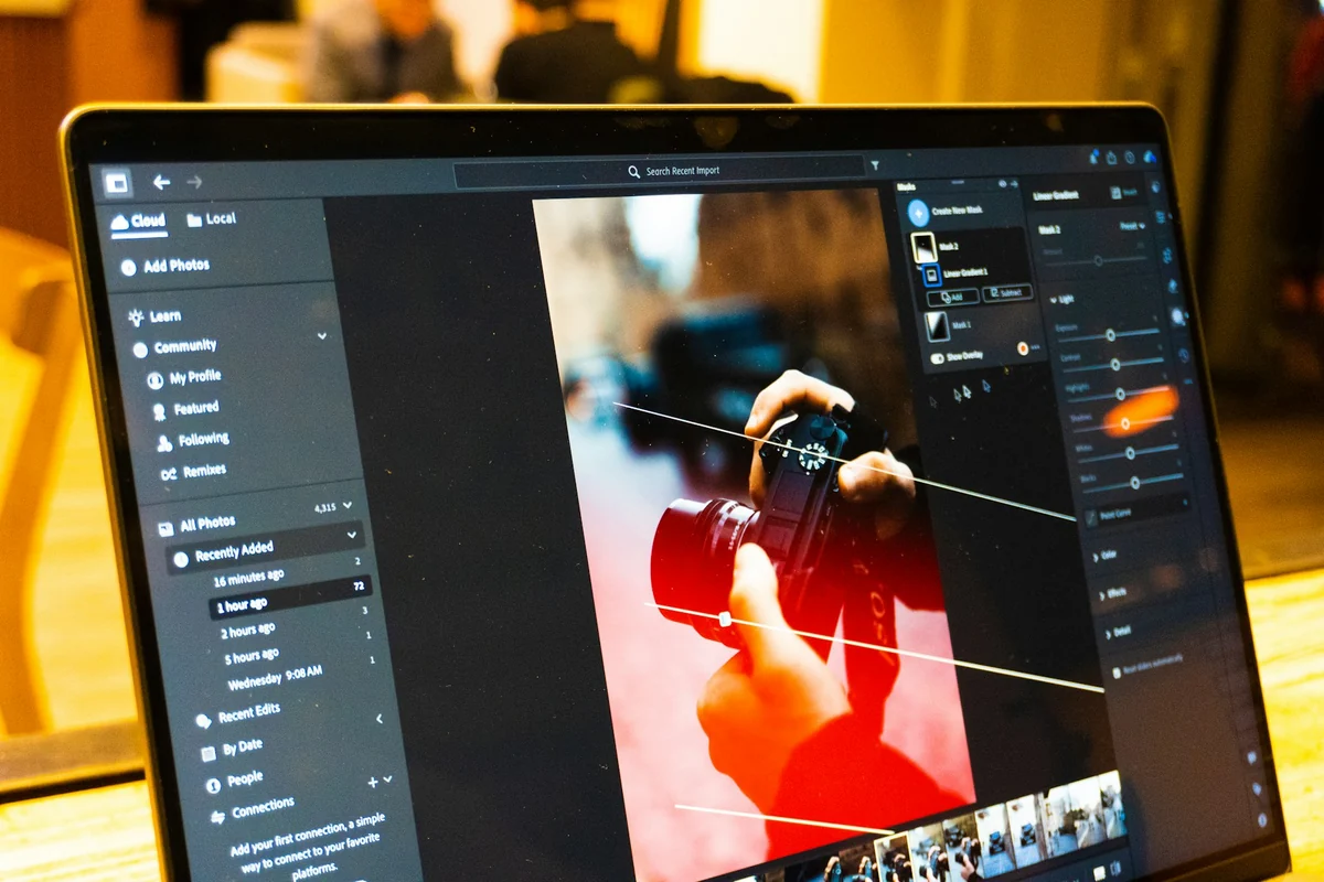 A laptop screen showing photo editing software with a photo of a camera open