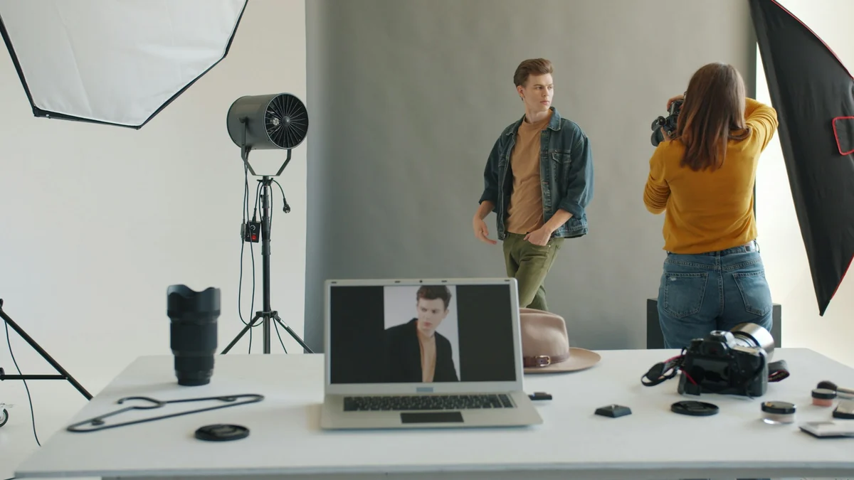 A studio portrait shoot with diffused lights, the model's photo showing on a laptop screen