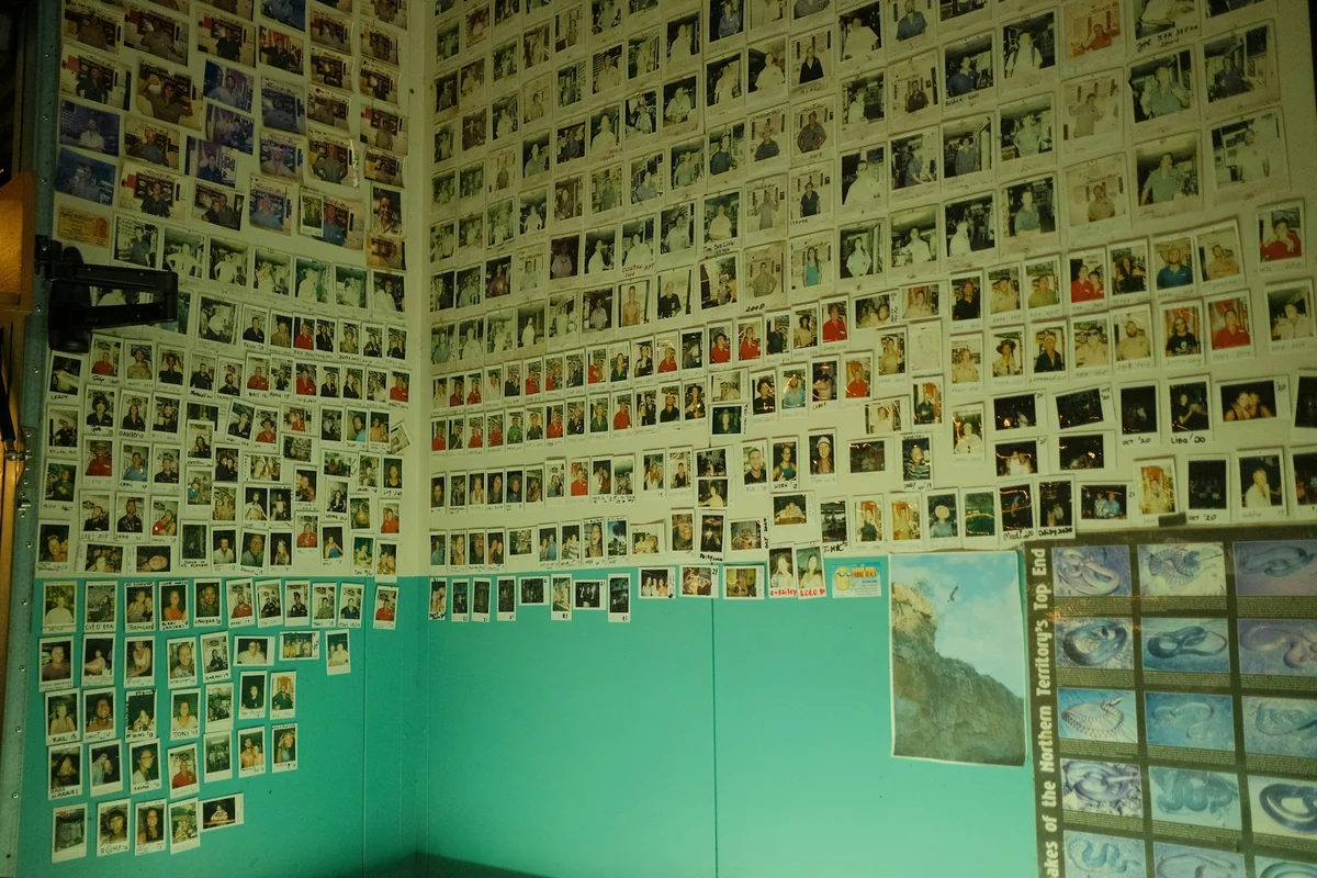 A wall covered with hundreds of portrait photos of many different people