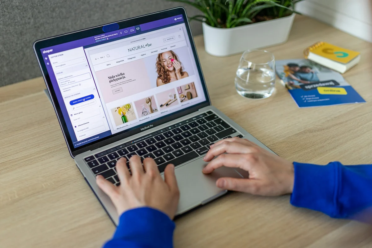 Person typing on a laptop with an online store dashboard open, showing product photos